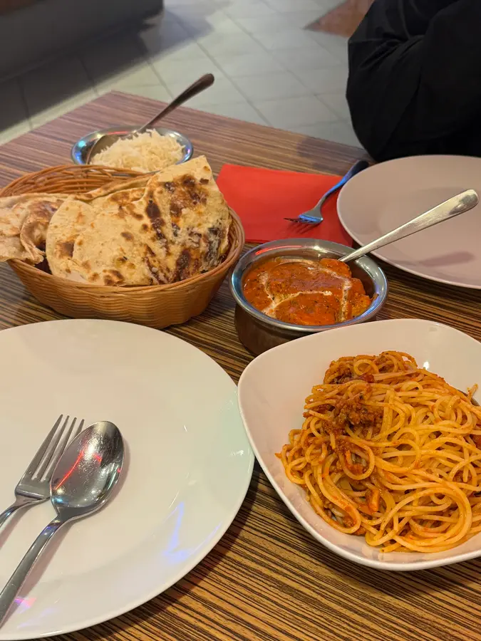 Spaghetti, Curry, Naan und Reis auf dem Tisch